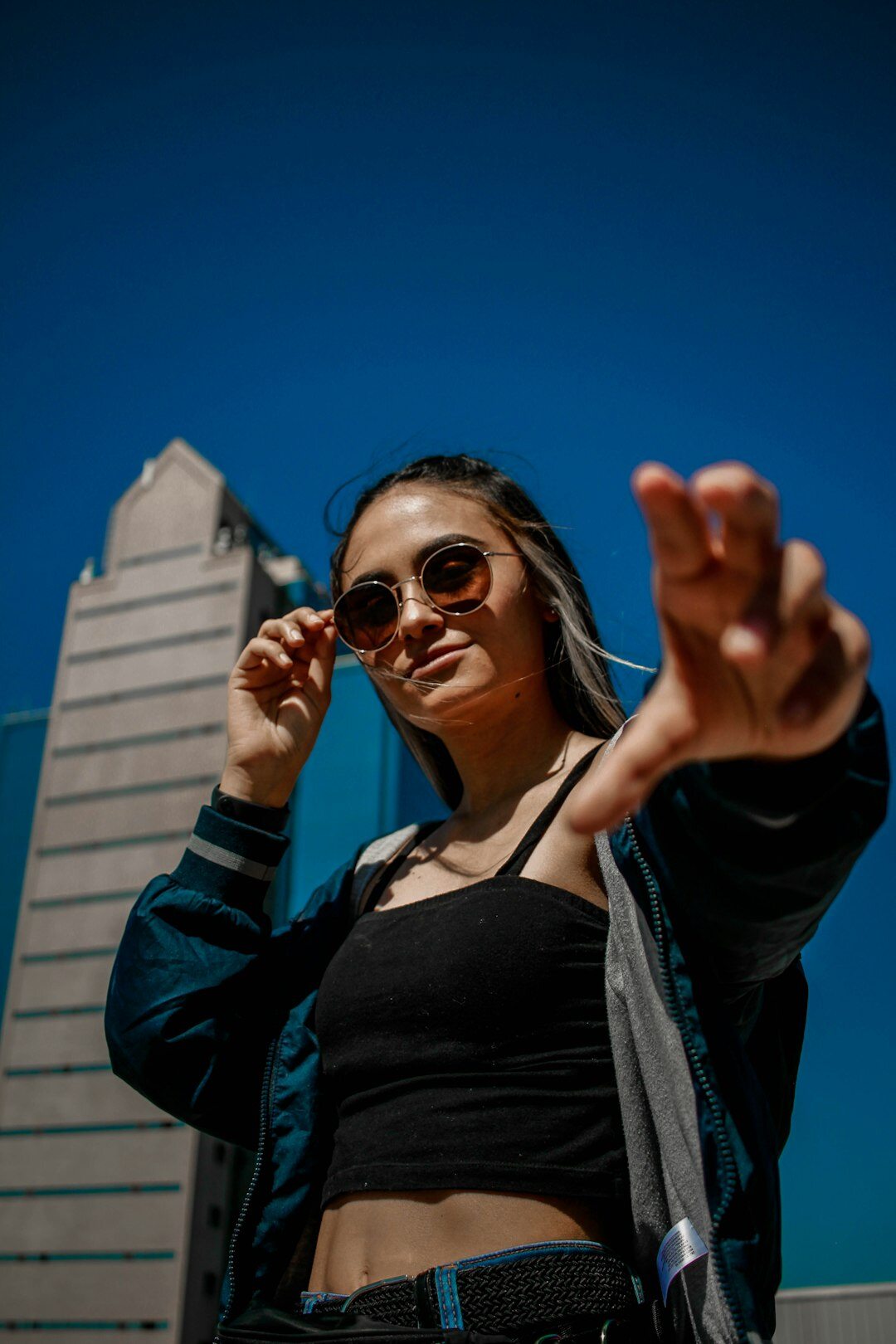 Stylish Hispanic woman wearing bold designer sunglasses outdoors