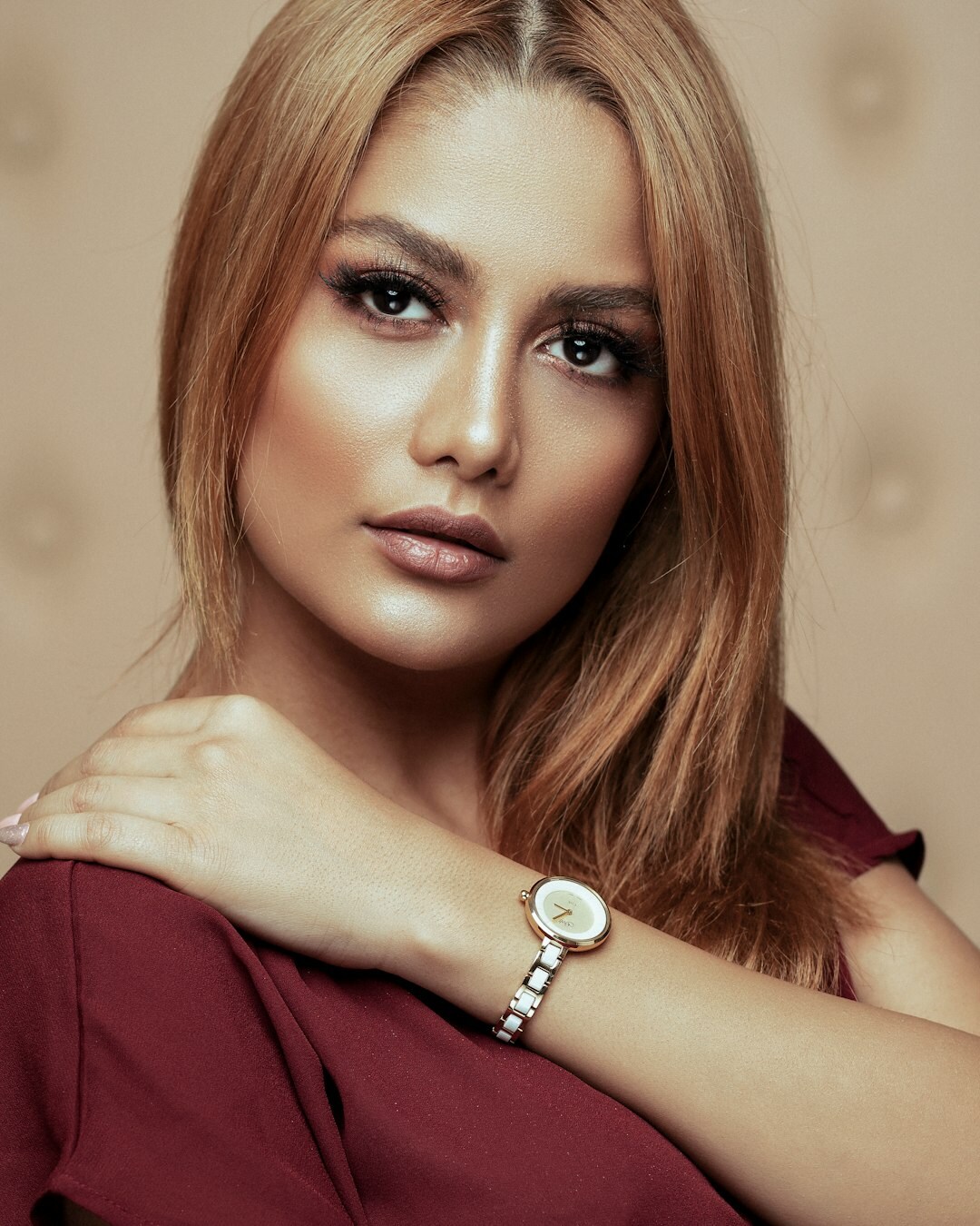 Elegant Hispanic woman wearing a diamond jewelry wristwatch and gold bracelet