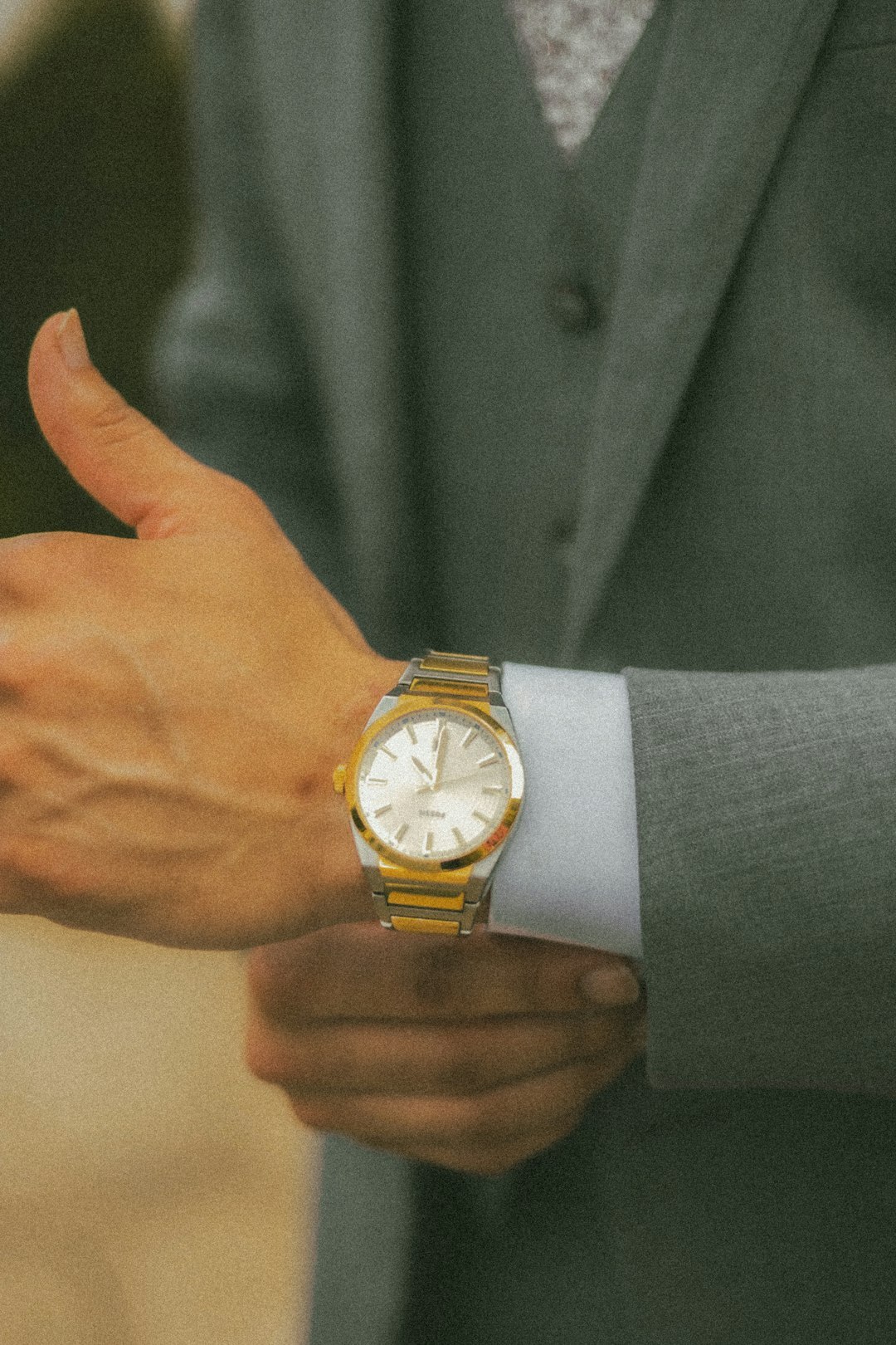 Close up of a slim gold dress watch worn on the wrist of a Hispanic professional man